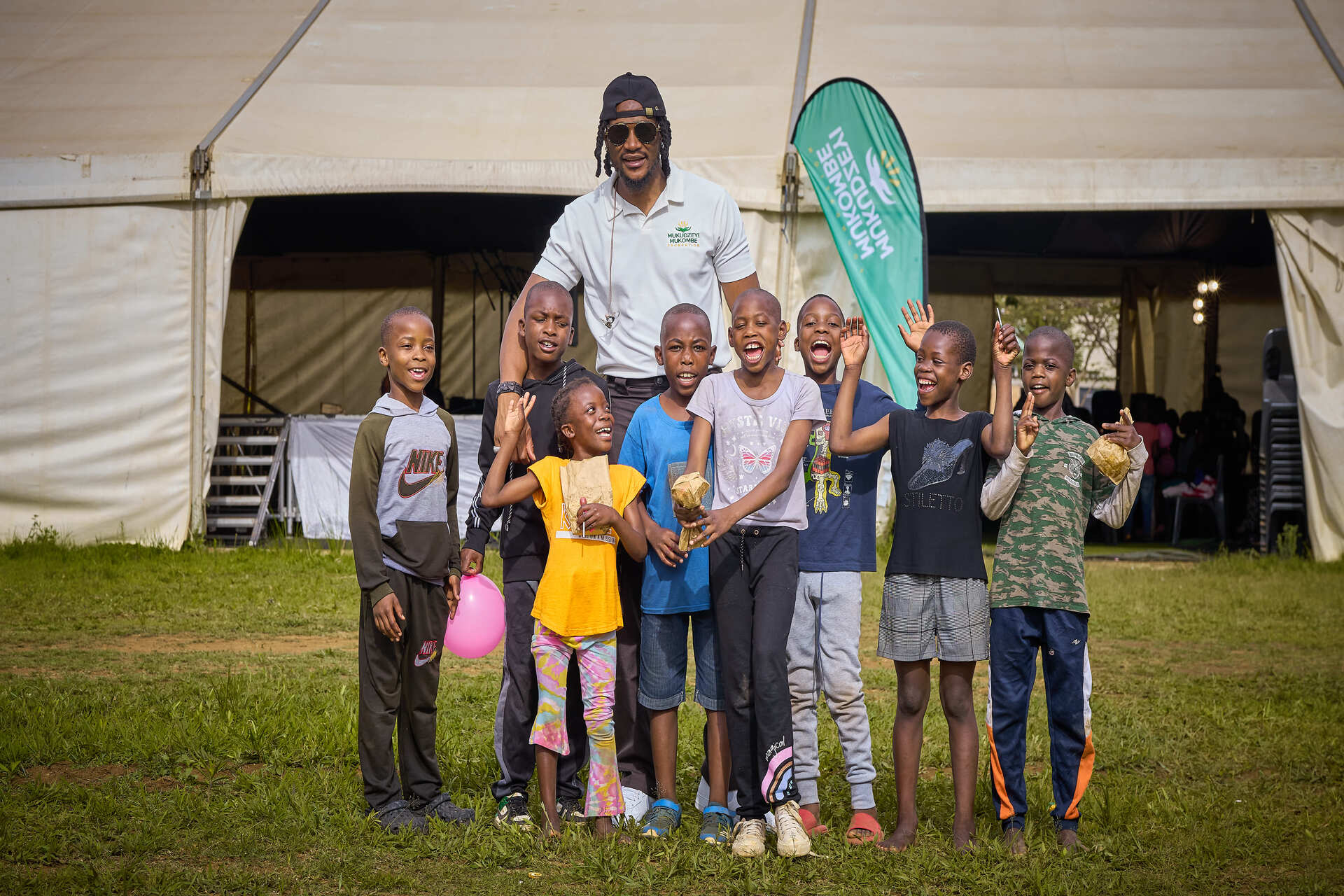 Founder Jah Prayzah greeting community members at an outreach event